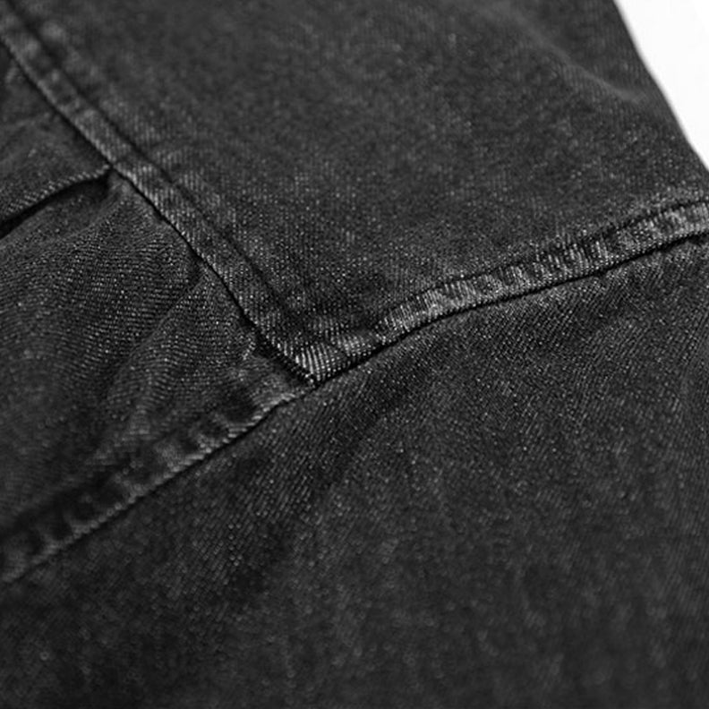 Close-up of black washed denim fabric with visible stitching and seam details, highlighting the texture and weave—ideal for an overshirt crafted from natural cotton.