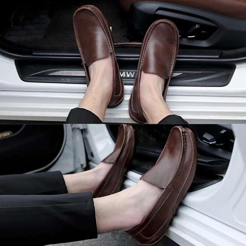 A person wearing genuine leather loafers with cushioned insoles and black pants sits in the open doorway of a white vehicle, resting their feet on the car’s door frame.