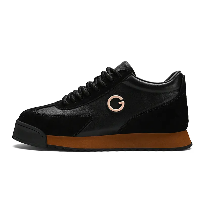 A black sneaker with a brown sole, black laces, and a metallic G logo on the side. These sleek sneakers feature luxe leather suede textures, a slightly elevated heel, and a modern design perfect for the urban professional.
