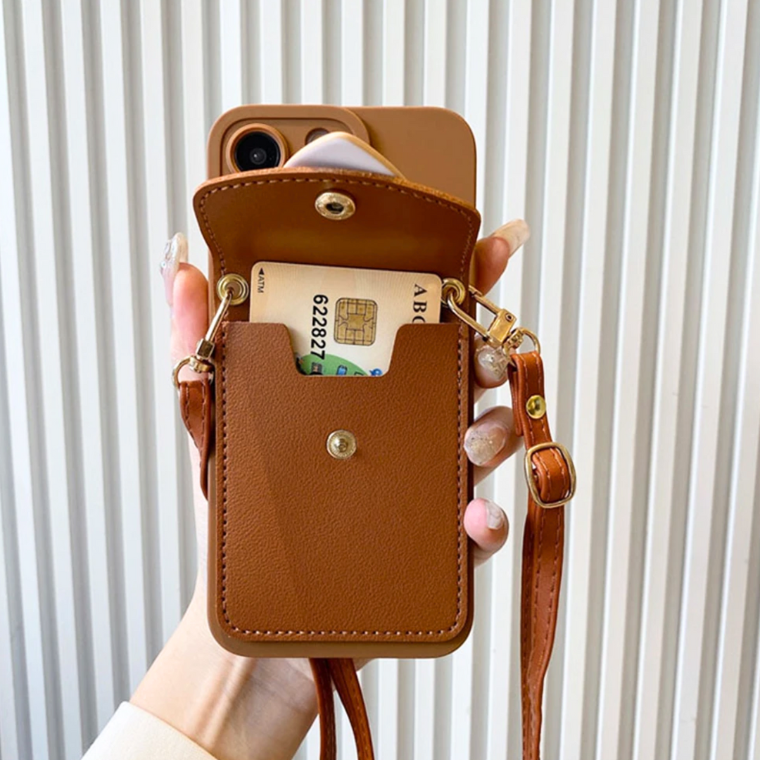A hand holds a chic phone case with a crossbody strap, featuring a snap pocket that contains a card and a folded piece of paper. The background is a white vertical striped wall.