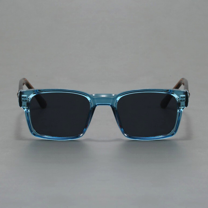 A pair of rectangular sunglasses with light blue translucent, durable frames and black lenses, offering UV400 protection, shown against a plain gray background.