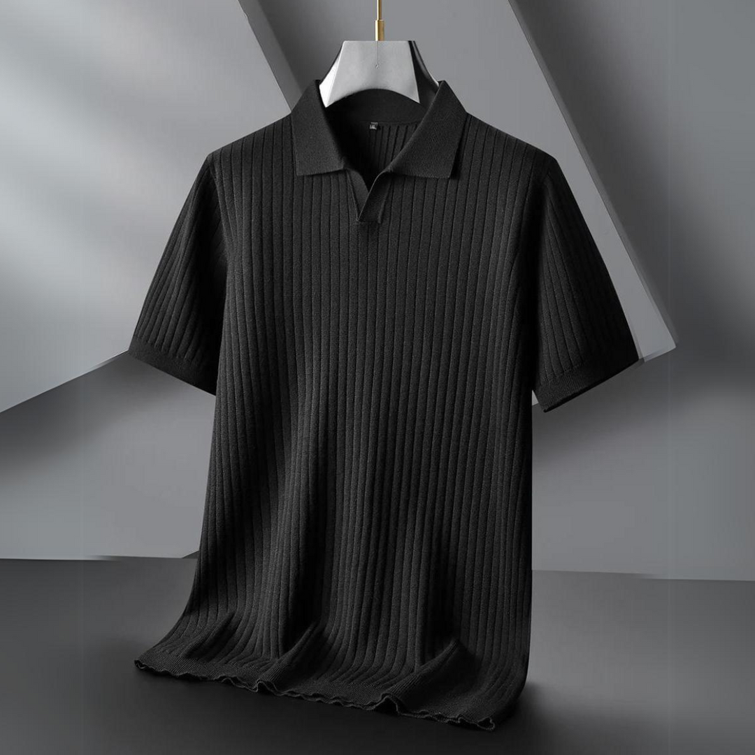 A black ribbed knit polo shirt hangs on a white hanger against a modern, geometric gray background. The shirt has a subtle vertical stripe texture and simple collar—perfect for the urban professional seeking effortless style.