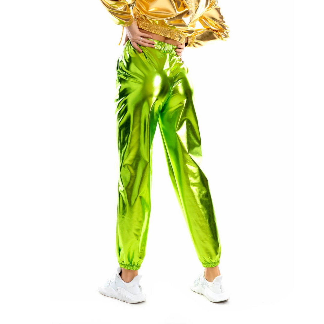 Person in shiny lime-green pants with an elastic high waist, white sneakers, and a gold metallic jacket stands with hands on hips against a white background.