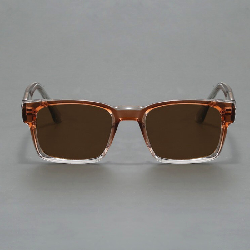 A pair of rectangular sunglasses with a modern design, featuring brown-tinted lenses, UV400 protection, and transparent brown plastic frames, displayed against a plain gray background.