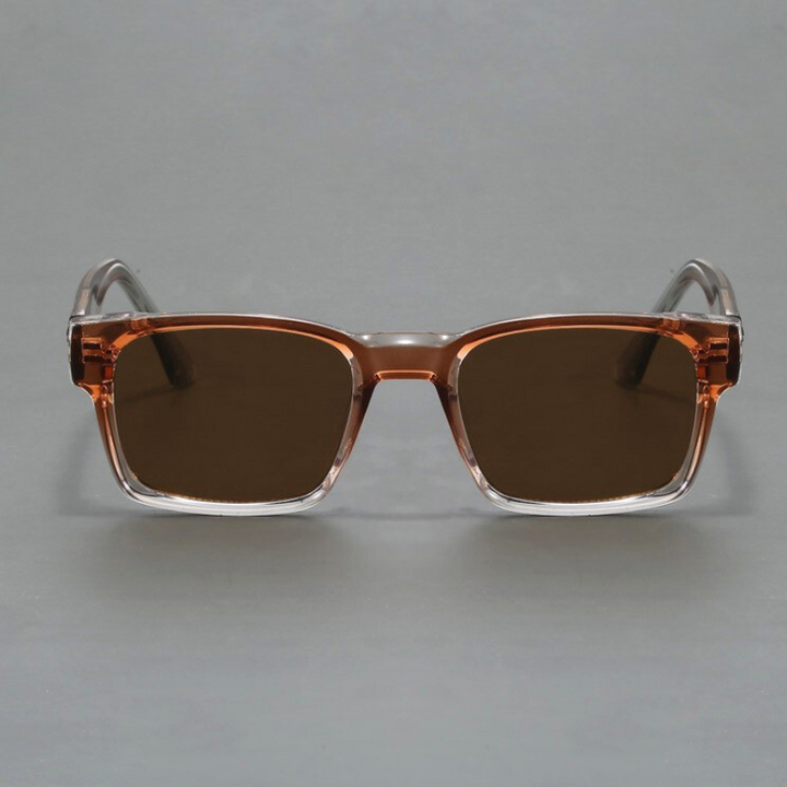 A pair of rectangular sunglasses with a modern design, featuring brown-tinted lenses, UV400 protection, and transparent brown plastic frames, displayed against a plain gray background.