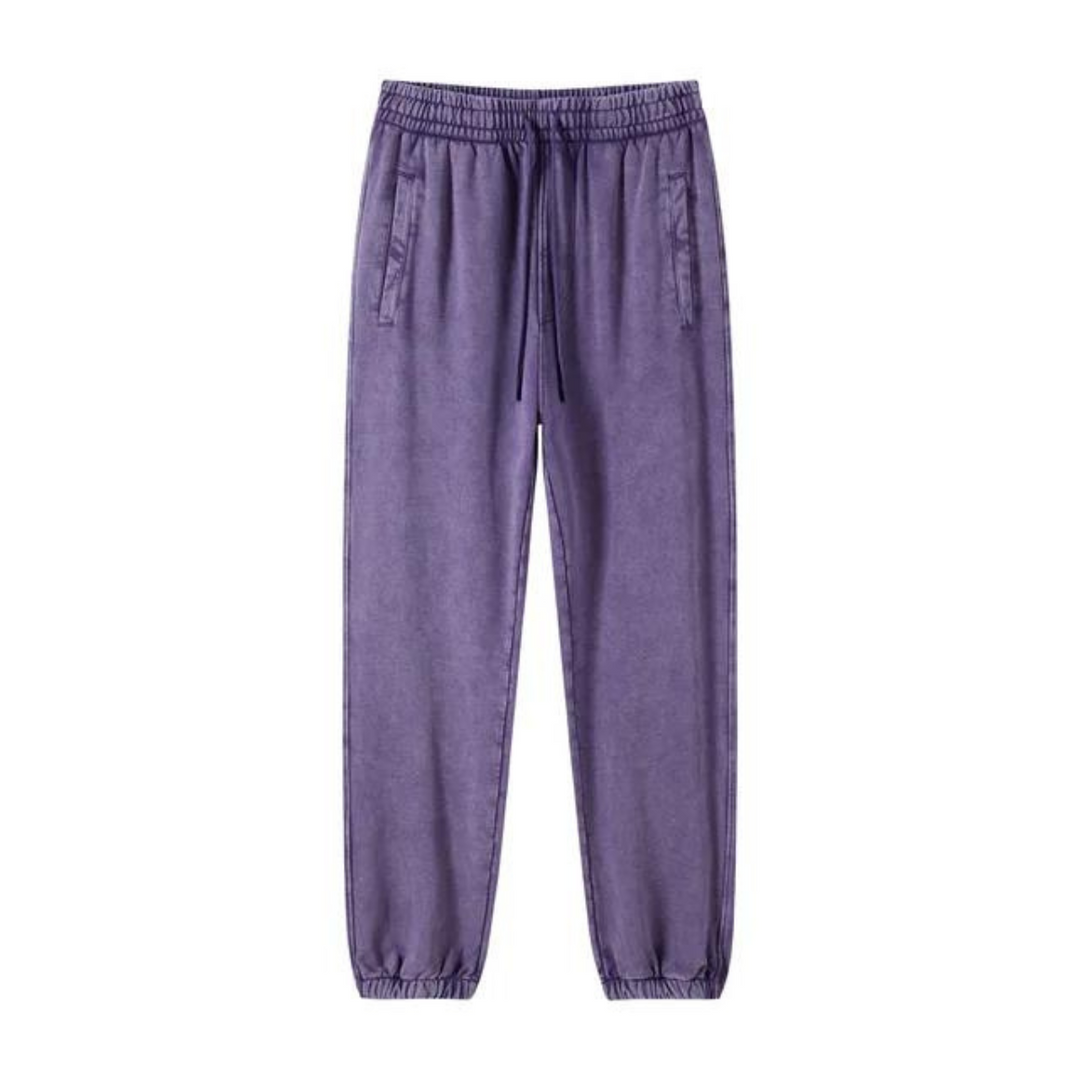 Purple jogger pants with an elastic waistband, deep pockets, drawstring, and tapered cuffs, displayed against a plain white background.