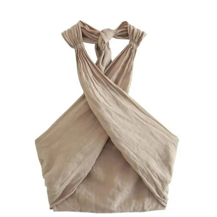 A sleeveless, light beige halter top with a chic halter collar and crisscross design in the front and back, featuring a twisted knot detail at the neckline. The soft, slightly textured fabric is perfect for effortless summer style.