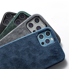 Four smartphones in textured alcantara phone cases—blue, gray, green, and black—are arranged diagonally with their camera lenses visible, showcasing the suede finish of each protective design against a white background.