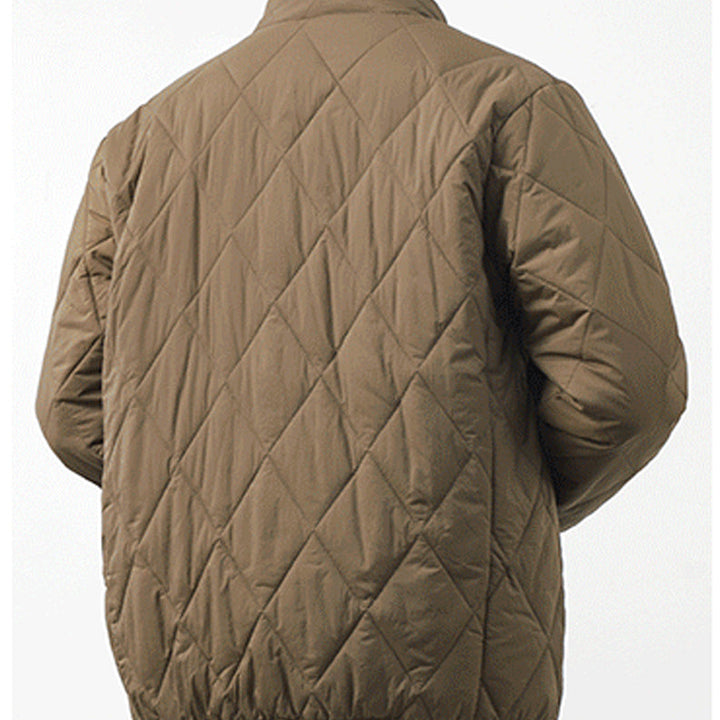 A person wearing a light brown, lightweight insulating padded jacket viewed from the back, featuring a diamond-stitched pattern and an elastic waistband against a plain background.