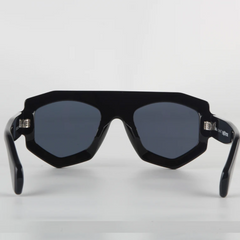 A pair of black, geometric frame sunglasses with dark lenses is shown facing forward on a white background. The thick acetate edges and angular corners give them a modern, bold style, while offering reliable UV400 protection.