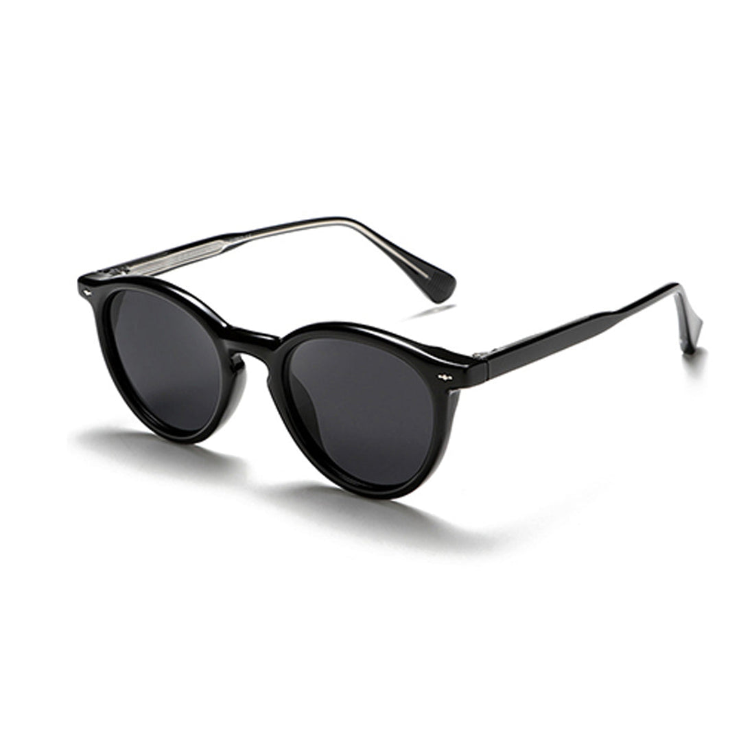 Black round frame sunglasses with dark lenses and slightly thick frames, positioned at a slight angle on a white background—perfect for those seeking fashionable eyewear with timeless appeal.