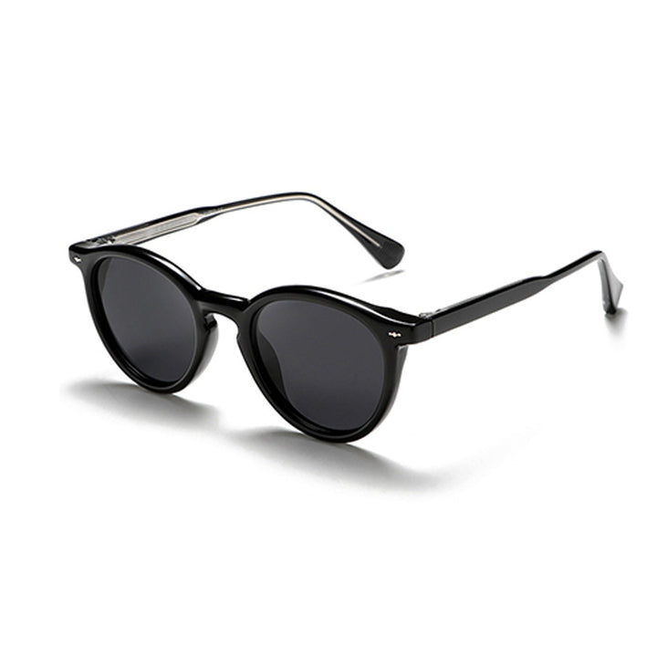 Black round frame sunglasses with dark lenses and slightly thick frames, positioned at a slight angle on a white background—perfect for those seeking fashionable eyewear with timeless appeal.