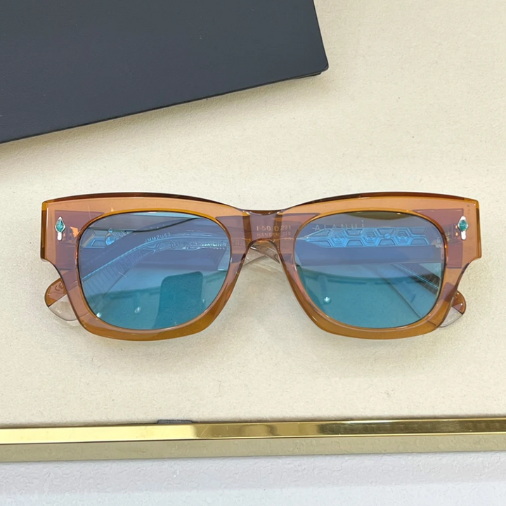 A pair of vintage-inspired sunglasses with brown translucent frames and blue-tinted lenses rests on a beige surface near a black object, blending retro style with modern flair.