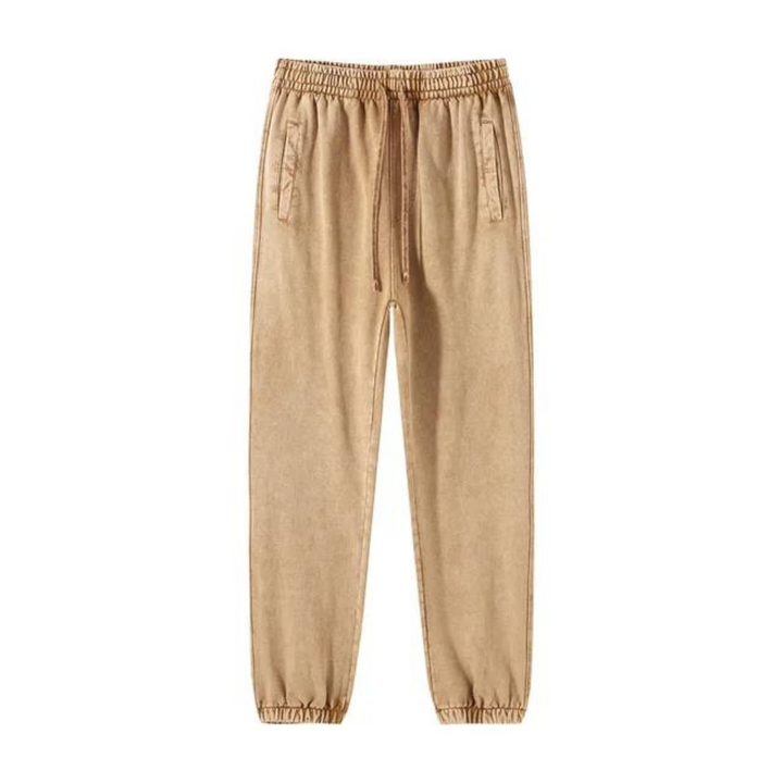 Beige jogger pants with an elastic waistband, drawstring, and tapered cuffs. They feature deep pockets and a relaxed fit, displayed on a plain white background.