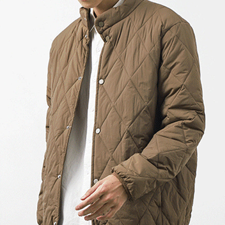 A person wearing a brown, lightweight insulating padded jacket with a diamond-stitched pattern over a white collared shirt, photographed from the shoulders down against a plain background.