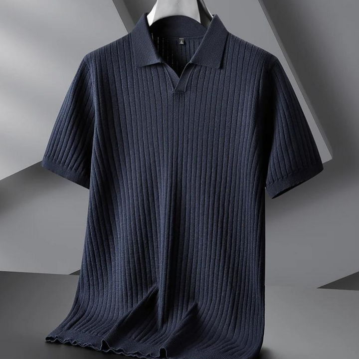 A navy blue, short-sleeved ribbed knit polo shirt hangs on a hanger against a gray geometric background. Perfect for the urban professional, it features a collar and a smooth, vertical ribbed texture.