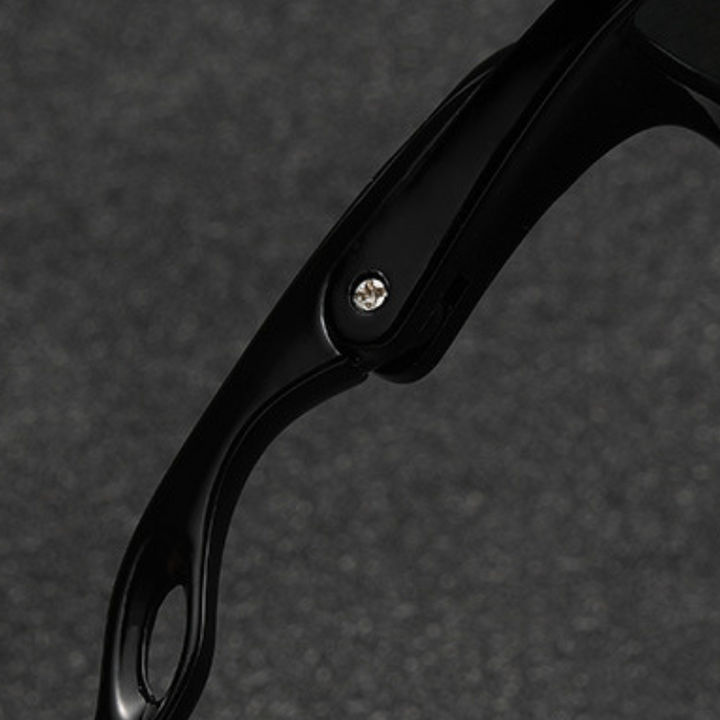 Close-up of a black plastic cycling sunglasses arm with a screw hinge, set against a dark, textured background.