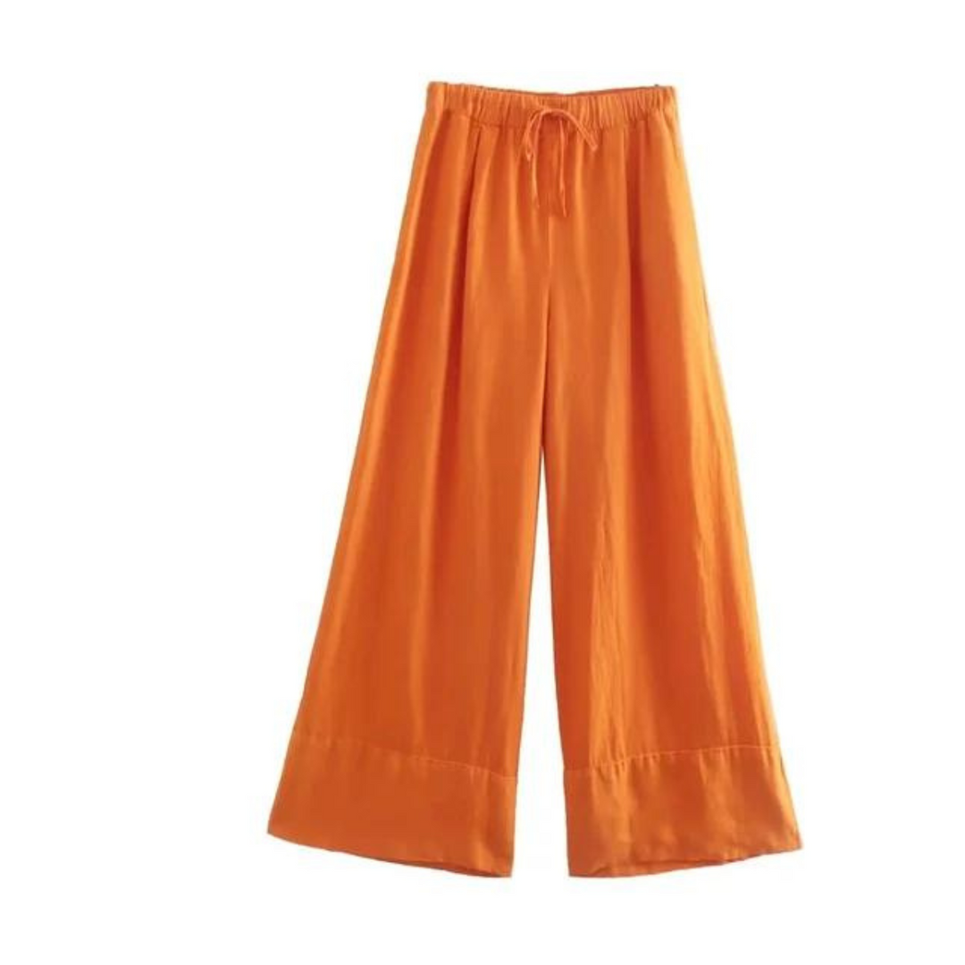 Wide-leg orange pants with an elastic waistband and drawstring, made of lightweight fabric, perfect for a breezy summer style. Displayed on a plain white background.