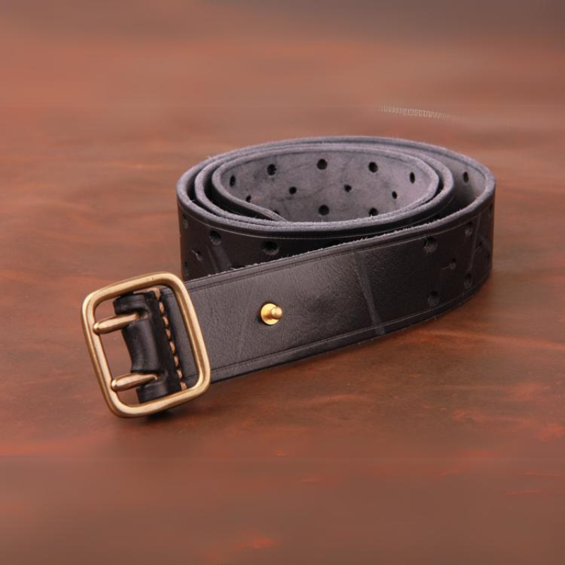 A rolled-up premium leather belt with a gold buckle and multiple adjustment holes, placed on a brown surface.