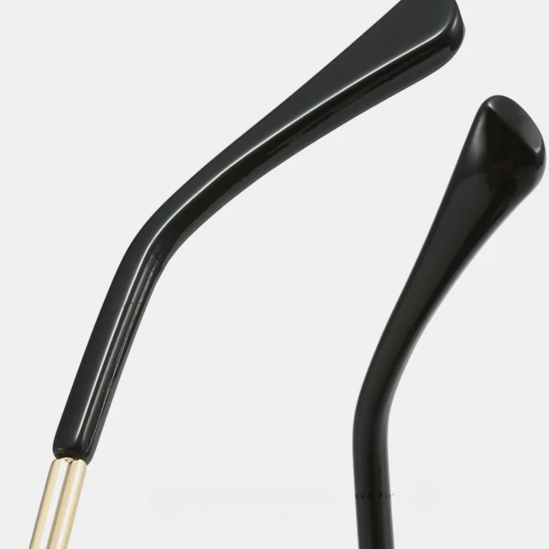 Close-up of two black eyeglass temples with gold hinges, showcasing premium metal frames against a plain white background.