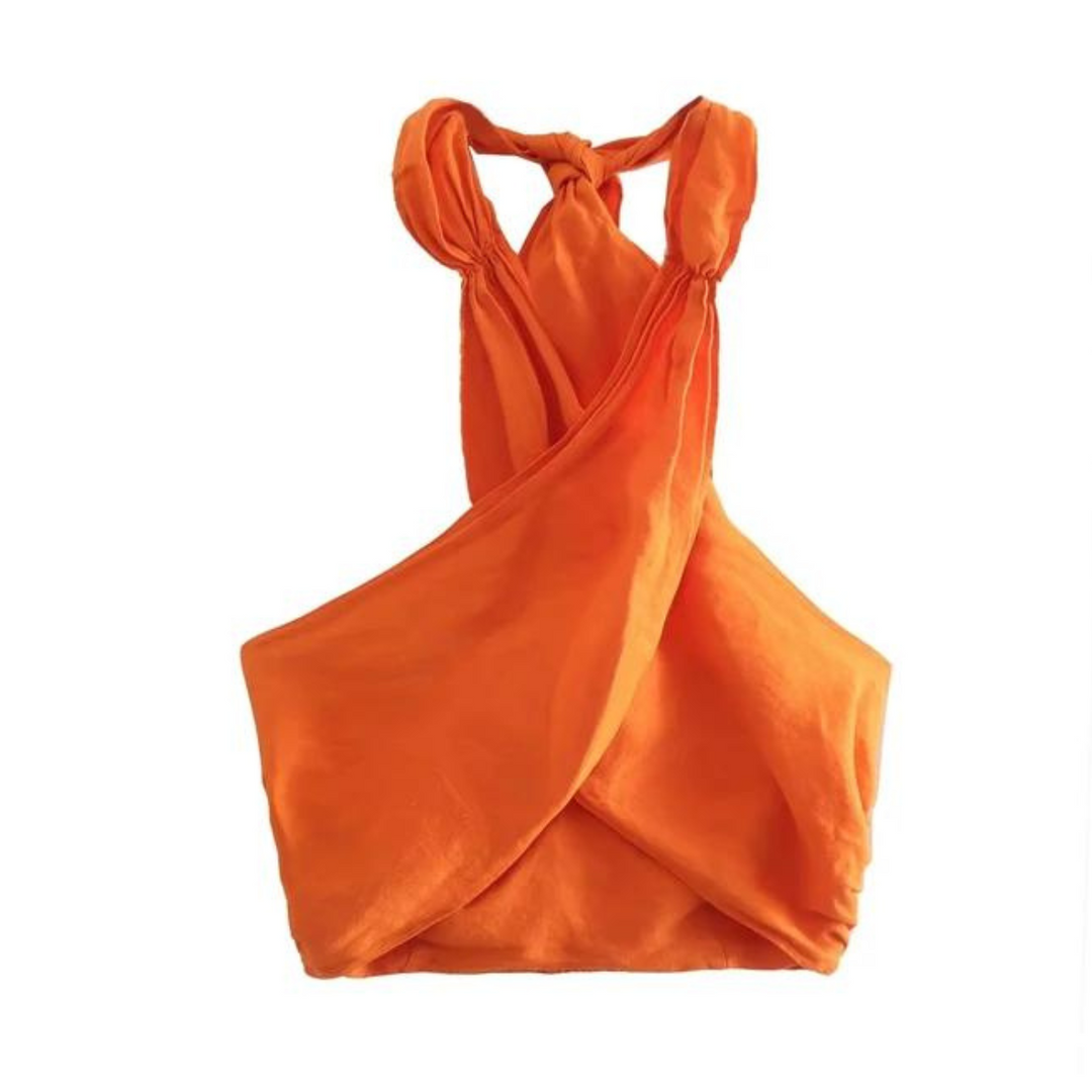 Bright orange, sleeveless crop top with a twisted halter collar and a crisscross front design, perfect for pairing with wide-leg pants for a chic summer style. Laid flat on a white background.