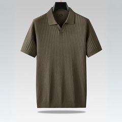 A short-sleeved, olive-green ribbed knit polo shirt with a vertical pattern, perfect for the urban professional, hanging on a black hanger against a light gradient background.