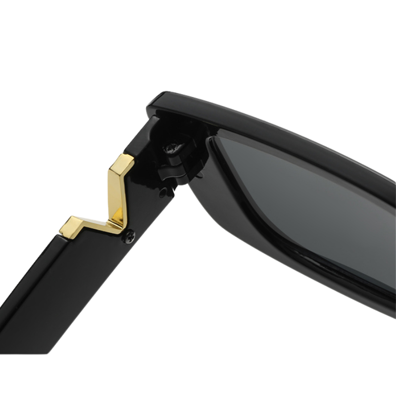 Close-up view of the hinge and arm of a pair of black designer sunglasses, featuring a gold decorative detail near the temple and sleek geometric frames.