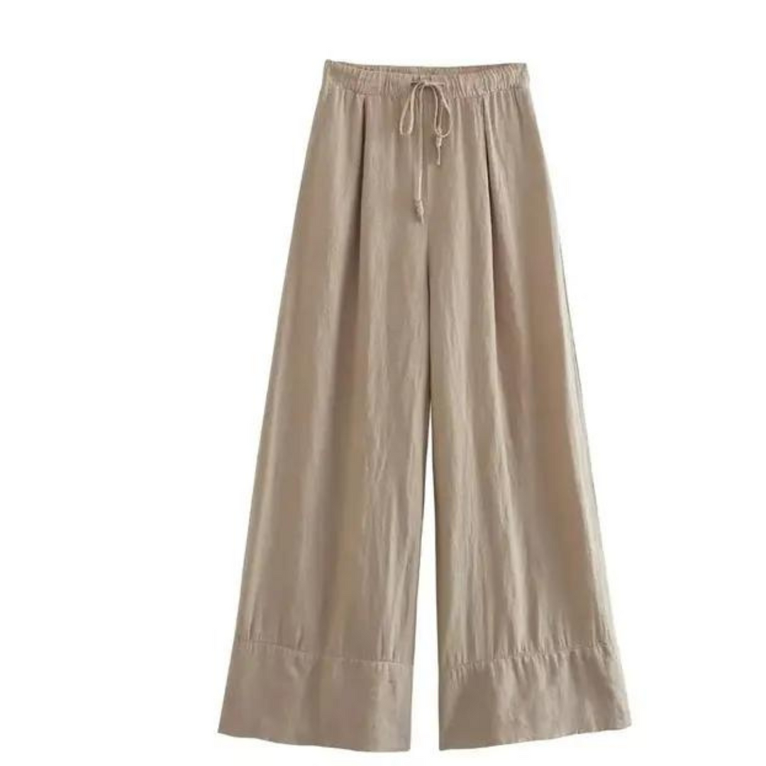 A pair of beige, wide-leg pants with an elastic waistband and drawstring, made from a lightweight fabric for effortless summer style, displayed on a white background.