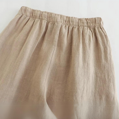 Beige linen wide-leg pants with an elastic waistband, shown from the waist down against a white background. The fabric appears soft and lightweight, perfect for effortless summer style.