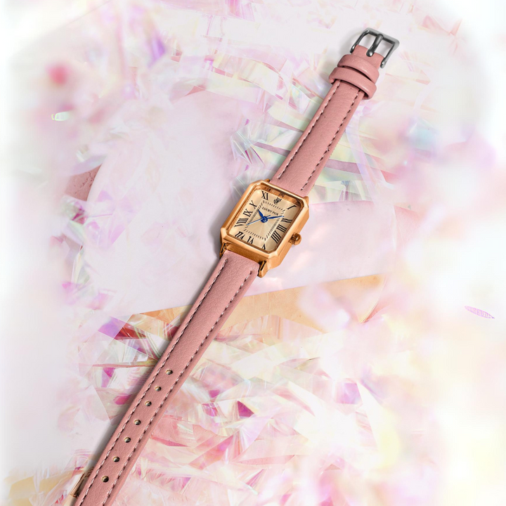A gold rectangular face watch with a genuine leather pink strap rests on a soft, iridescent background with pastel colors and shimmering textures.