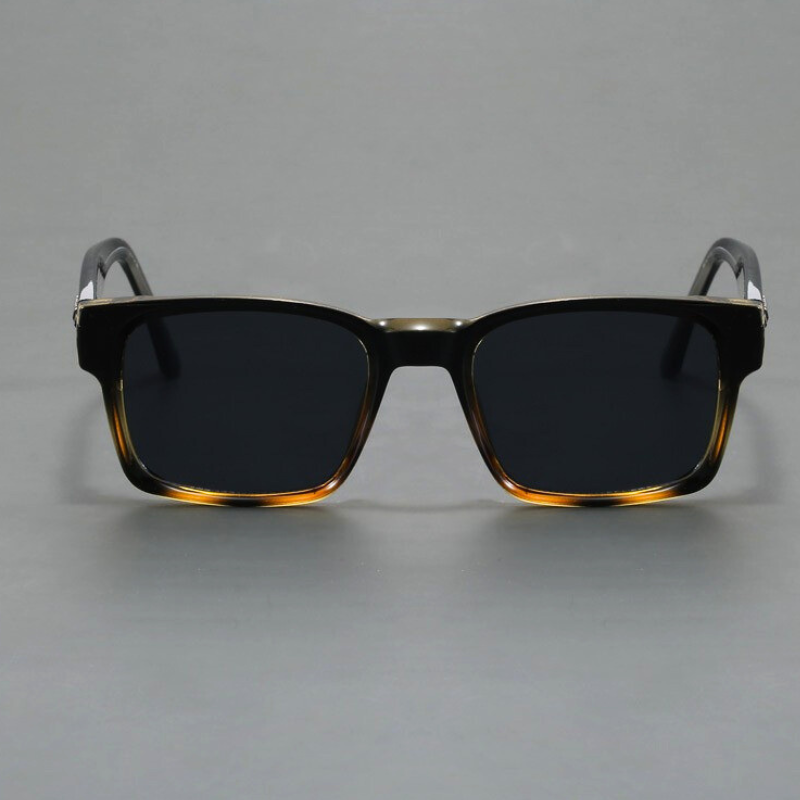 A pair of black rectangular sunglasses with durable frames, dark lenses, and a subtle gradient brown detail at the bottom of the frames, displayed against a plain gray background.