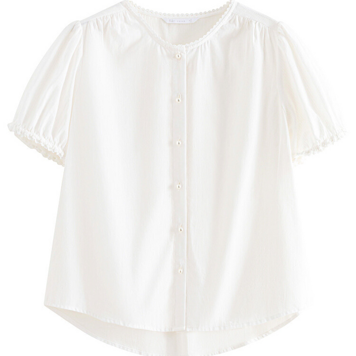 A white lace trim blouse featuring short puffed sleeves, a round neckline, small white buttons down the front, and delicate lace on the cuffs and collar—perfect as a versatile blouse for any occasion.