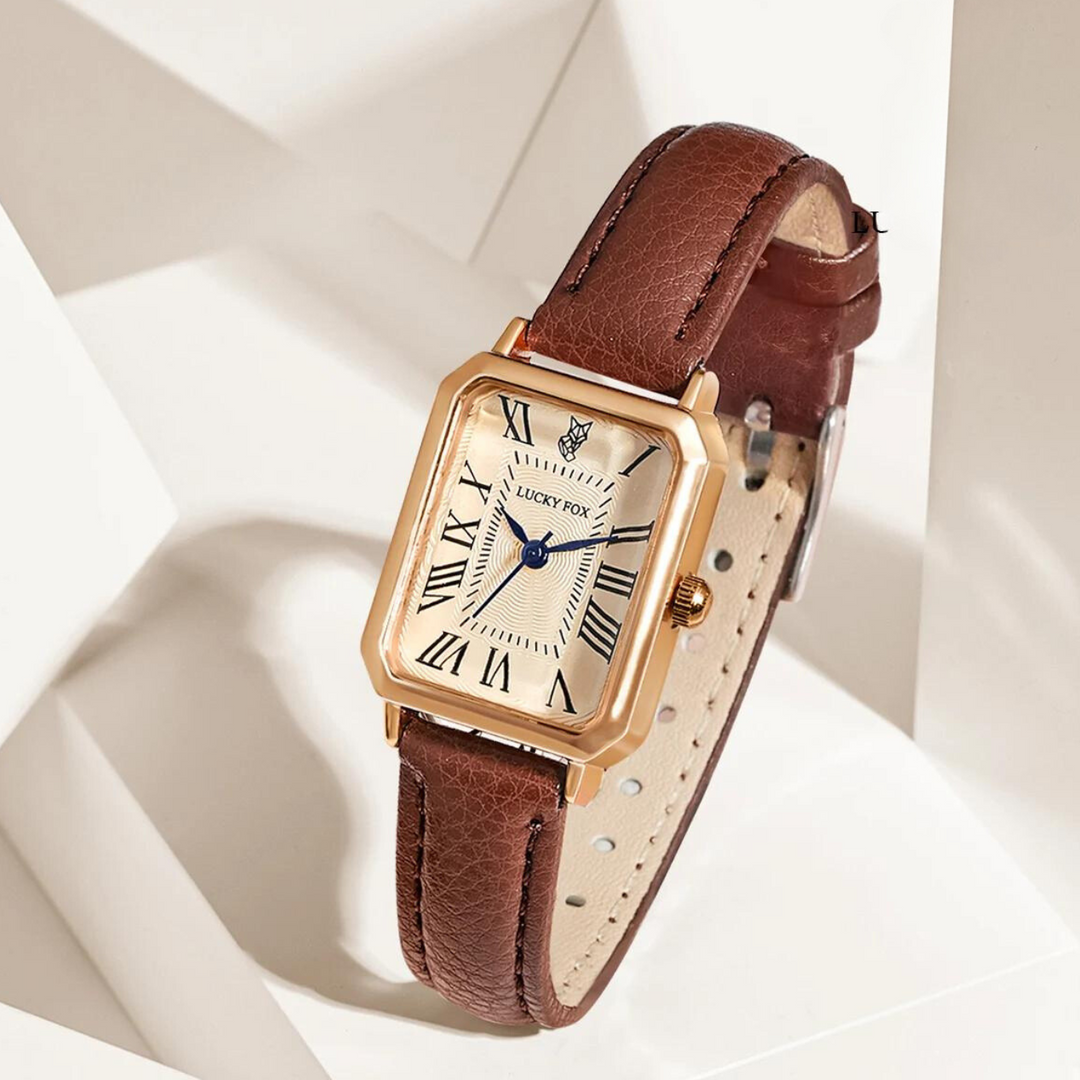 A rectangular face watch with a white dial, black Roman numerals, blue hands, and a genuine leather strap is displayed on a geometric white background.