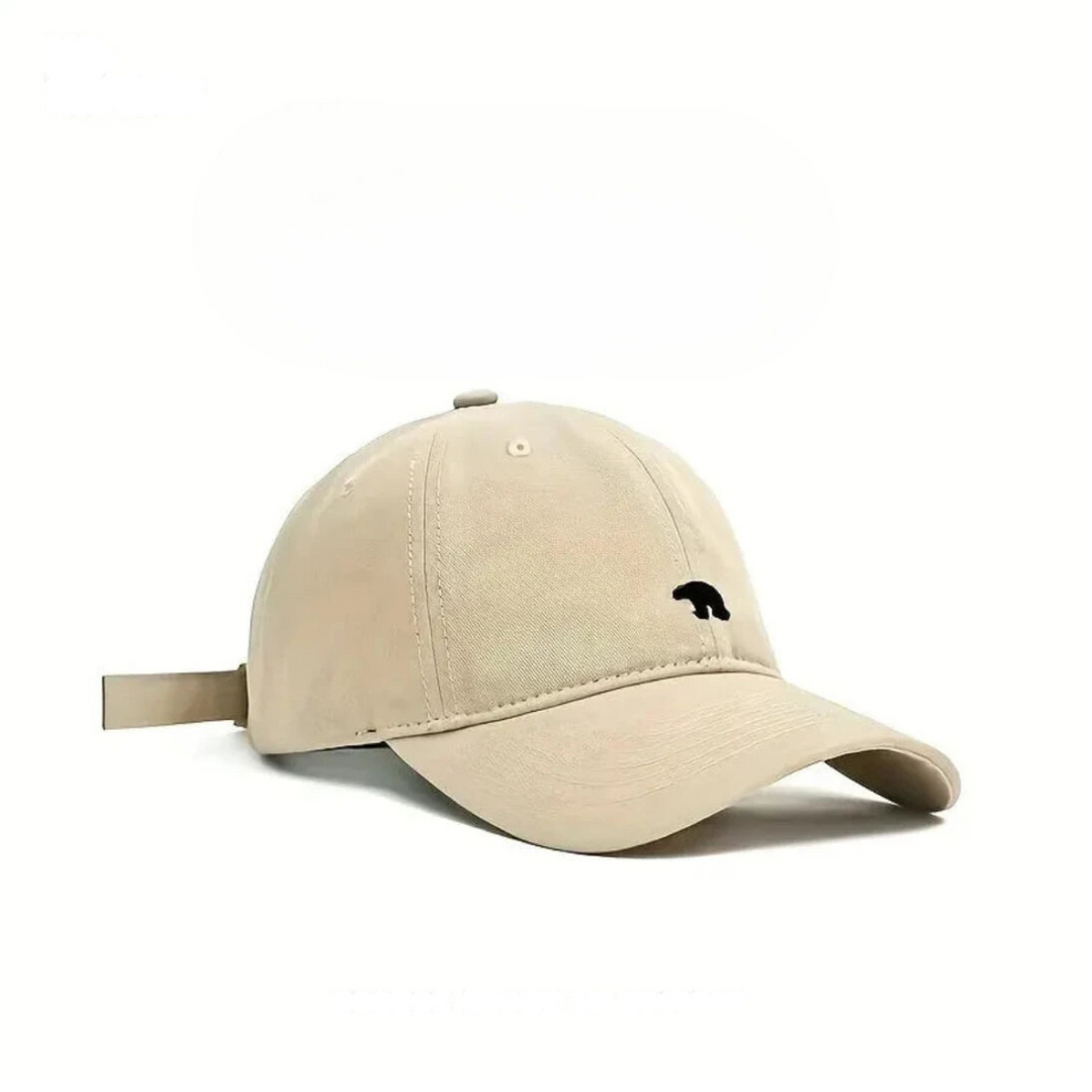 A beige baseball cap made from premium cotton with a small black bear silhouette embroidered on the front, shown against a plain white background.