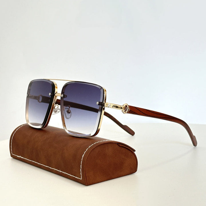 Square-shaped vintage sunglasses with gold metal frames, wooden arms, and gradient blue lenses sit atop a brown leather case with white stitching, set against a plain white background.