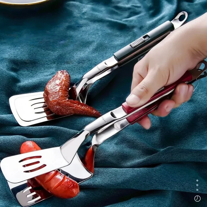 A hand uses spatula tongs with black and red handles to pick up cooked sausage links from a teal cloth surface—perfect grilling tools for BBQ season.