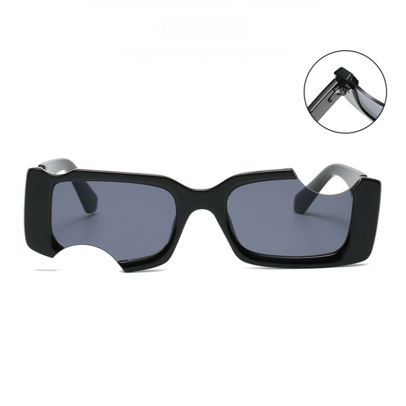 Rectangular black avant-garde sunglasses with dark lenses and a unique circular cutout on the left lens. An inset highlights the hinge detail on the arm. These irregular sunglasses offer eye-catching style and reliable UV400 protection.