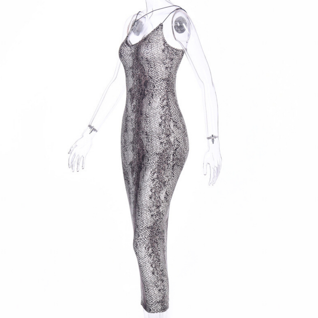 A sleeveless, fitted, ankle-length animal print dress with a grey and black snakeskin pattern is displayed on a clear, headless mannequin against a white background, making it the perfect summer statement dress.