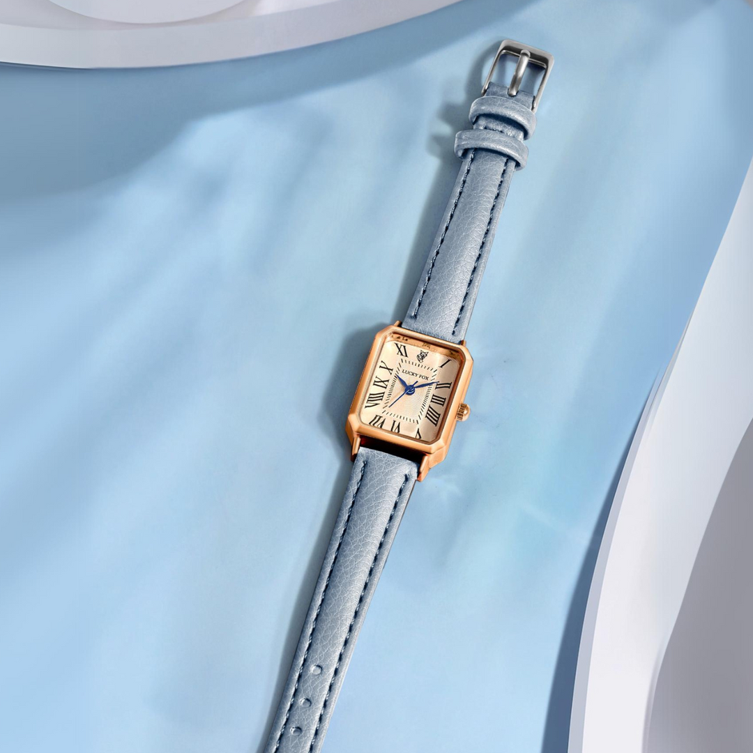 A rectangular face watch with a light blue genuine leather strap and white dial featuring Roman numerals, displayed on a soft blue background.