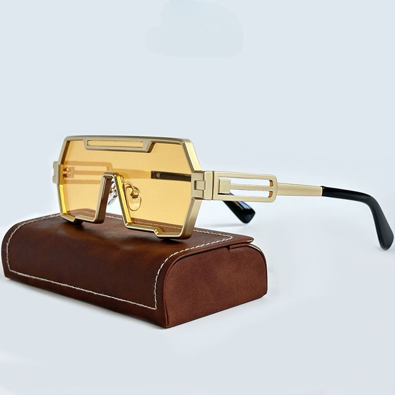 Futuristic Steampunk Sunglasses with gold-rimmed square frames and rectangular, yellow-tinted lenses are displayed on a brown leather case against a light background.