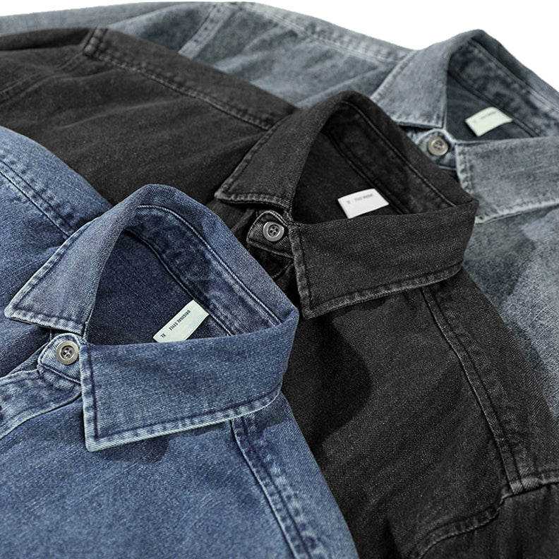 Three washed denim shirts in blue, black, and gray shades are laid out, overlapping to showcase their collars and top buttons. Each overshirt features visible inside tags near the neck.