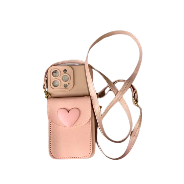 A chic phone case in pink with a heart-shaped pocket on the front, perfect for holding your smartphone, and finished with a matching adjustable crossbody strap.