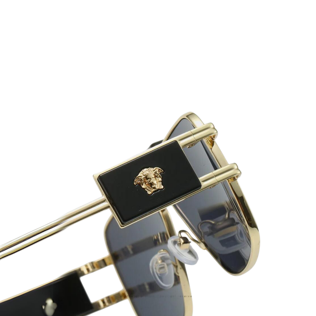 Close-up of bold sunglasses with premium metal frames, gold Medusa head emblem on the temple, and black accents. The tinted lenses offer UV400 protection, while adjustable nose pads ensure comfort and style.
