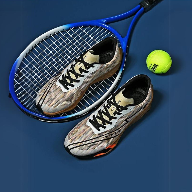 Two multicolored athletic shoes with a shock-absorbing sole are placed on top of a blue tennis racket next to a bright yellow tennis ball, all set against a dark blue background.