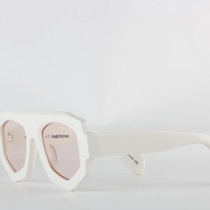 White oversized sunglasses with a bold geometric frame crafted from acetate and light pink-tinted lenses. The thick, angular edges create a modern look, while UV400 protection ensures stylish sun safety against a plain white background.
