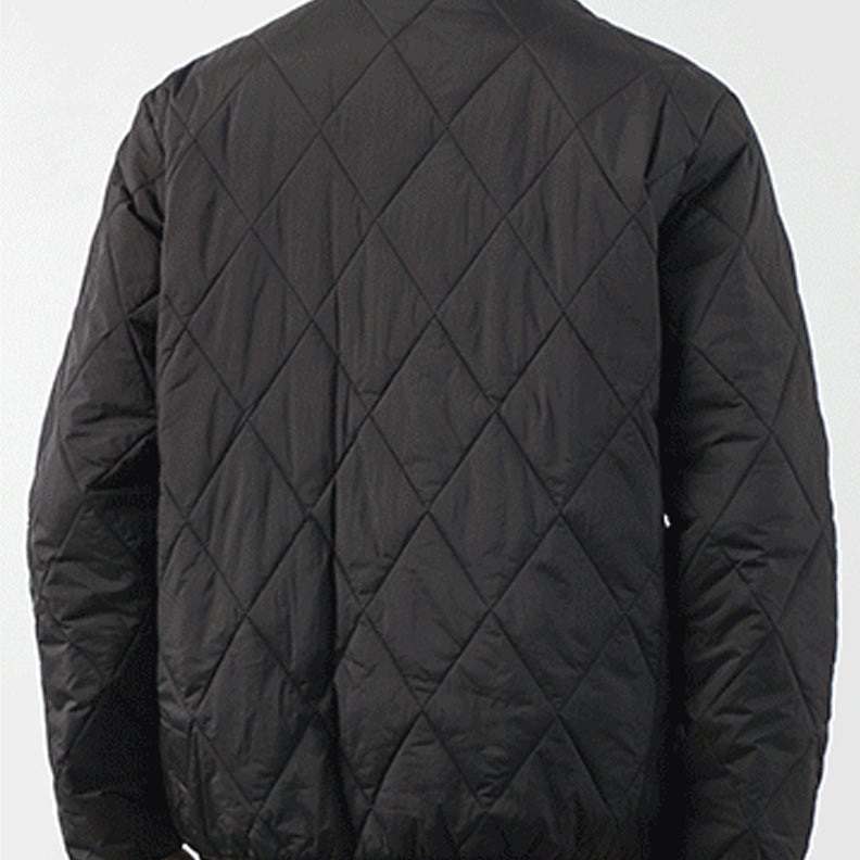 A person wearing a black padded jacket, shown from the back. The jacket features a diamond-stitched pattern and has a slightly loose fit. The background is plain and light-colored.