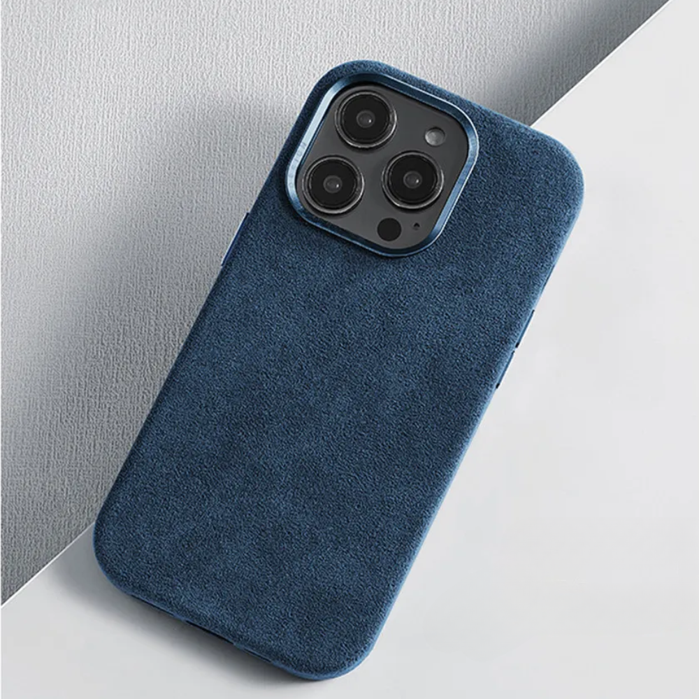 A smartphone with a blue suede finish protective design lies on a white and light gray geometric surface, its camera lenses prominently visible.