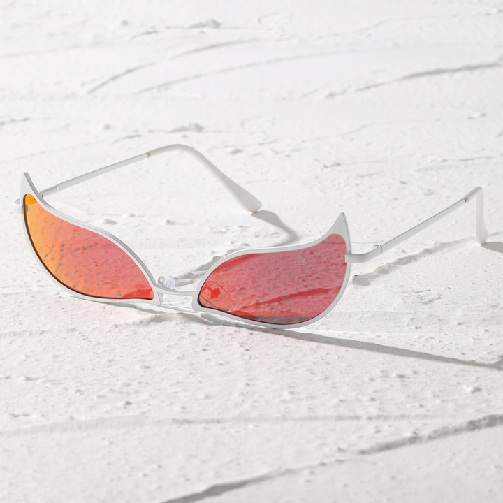 White-framed, futuristic sunglasses with red, iridescent, wing-shaped lenses and a lightweight frame offer UV400 protection, resting on a textured white surface.