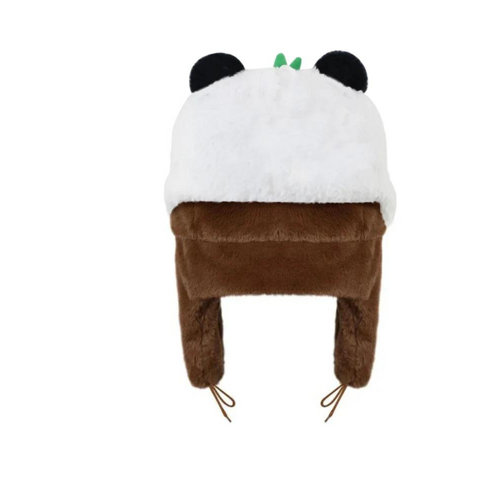 A furry winter hat designed to look like a panda, featuring plush material, a white top, black round ears, a small green leaf detail, and brown adjustable ear flaps with strings.