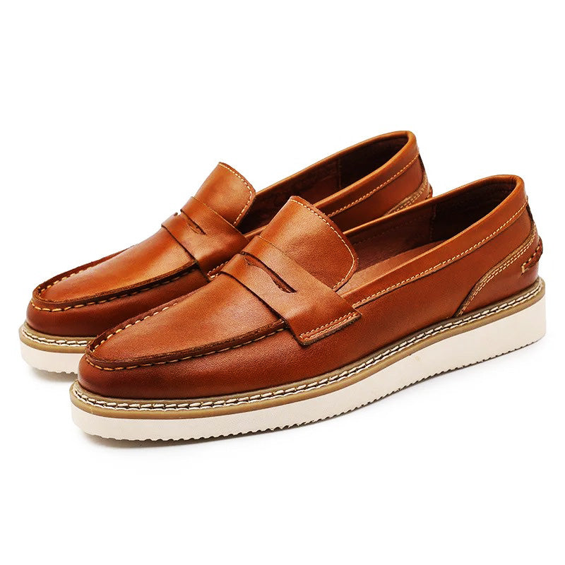 A pair of brown Italian leather penny loafers with white rubber soles and visible stitching, perfect for a business casual look, displayed on a white background.